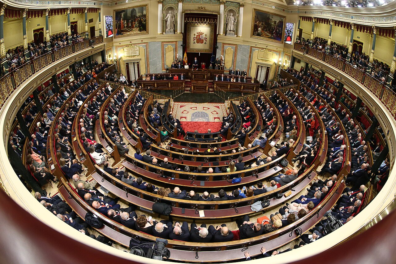 Vista del hemiciclo del Congreso de los Diputados lleno: filas de asientos en semicírculo frente a la mesa presidencial